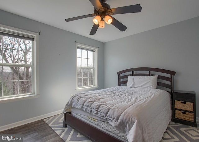 bedroom featuring wood finished floors, baseboards, and ceiling fan