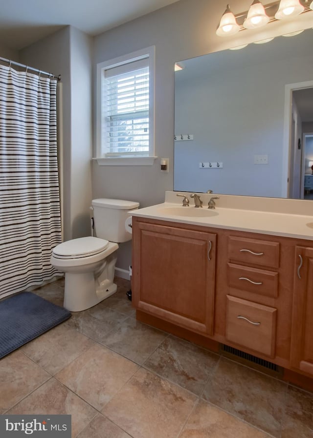 bathroom with vanity, toilet, a shower with curtain, and visible vents