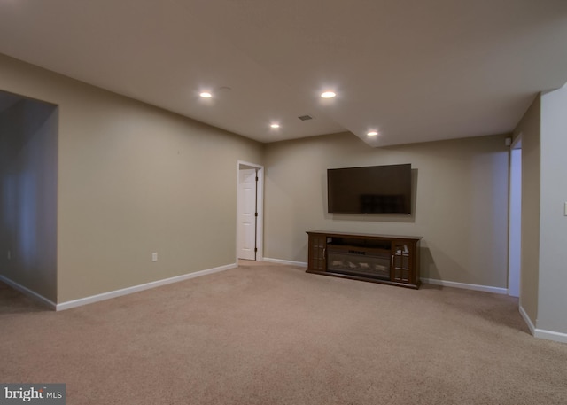 below grade area with visible vents, baseboards, carpet flooring, recessed lighting, and a fireplace