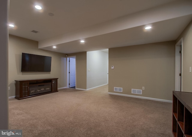 finished below grade area featuring visible vents, recessed lighting, and carpet