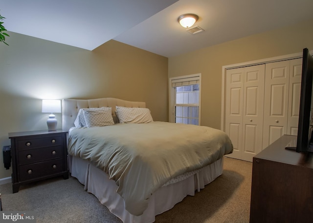 bedroom with light colored carpet, visible vents, and a closet