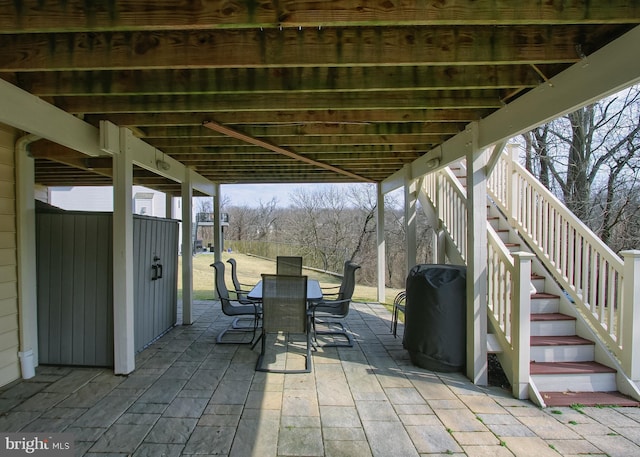 view of patio / terrace featuring outdoor dining space and stairs