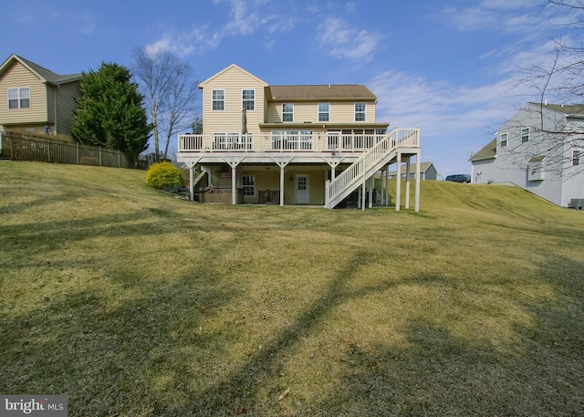 back of property featuring stairway, a lawn, a deck, and fence