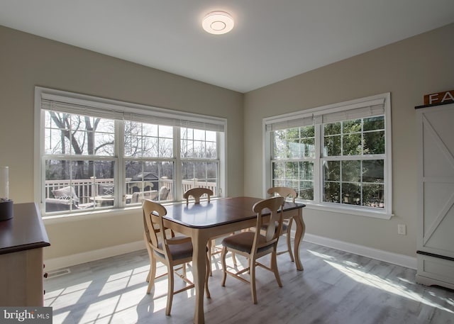 dining area featuring light wood-style floors and baseboards