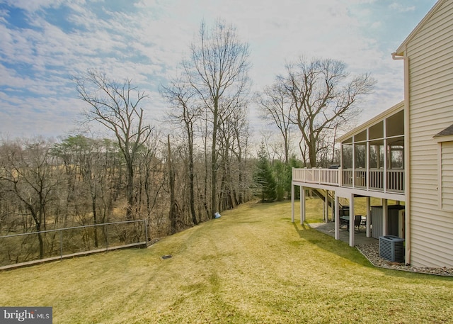 view of yard featuring central AC unit, a patio, a deck, and a sunroom