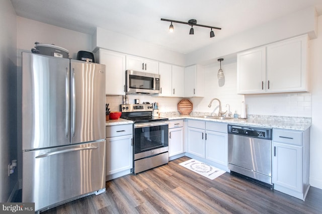 kitchen featuring sink, white cabinetry, hanging light fixtures, dark hardwood / wood-style flooring, and appliances with stainless steel finishes