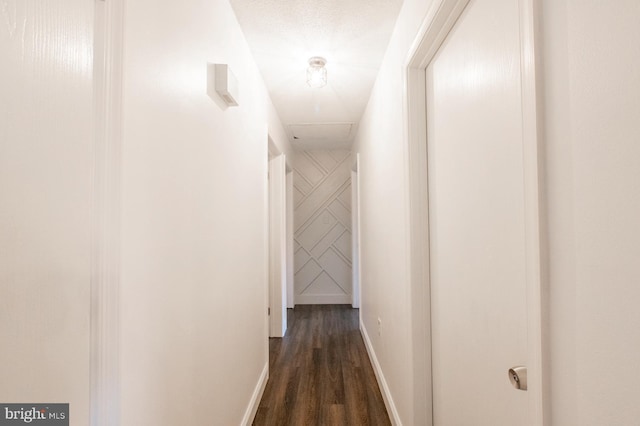 corridor with dark wood-type flooring and a textured ceiling