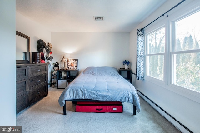 carpeted bedroom featuring a baseboard heating unit