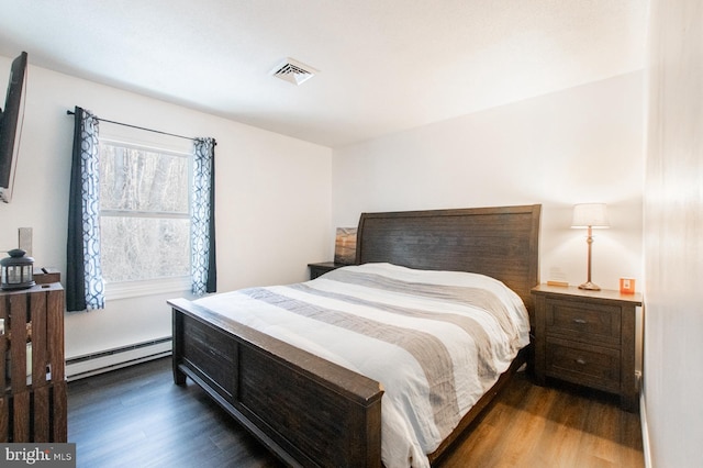 bedroom featuring dark hardwood / wood-style floors and a baseboard heating unit