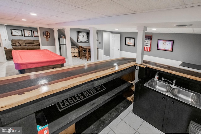 bar with wooden counters, light tile patterned floors, billiards, a drop ceiling, and sink