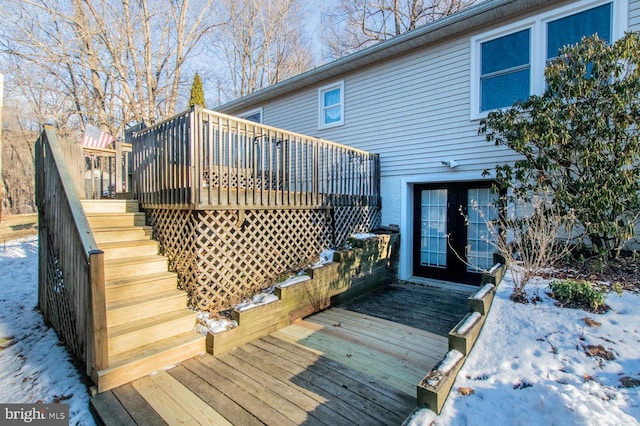 snow covered deck featuring french doors