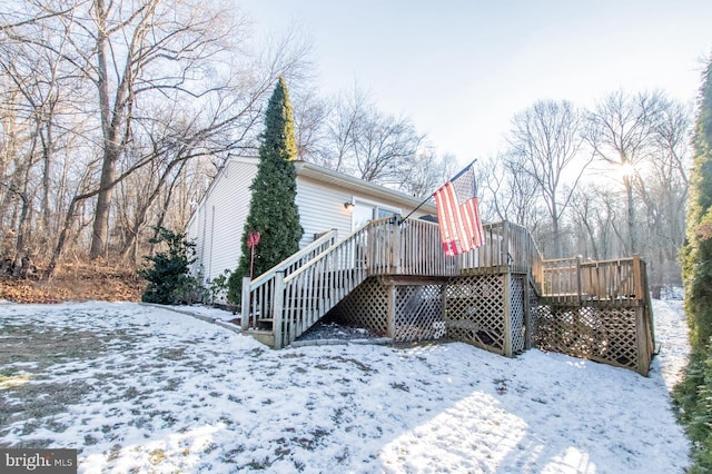 snow covered rear of property featuring a wooden deck