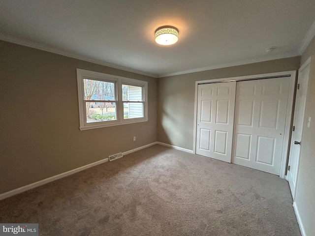 unfurnished bedroom featuring a closet, ornamental molding, and carpet flooring