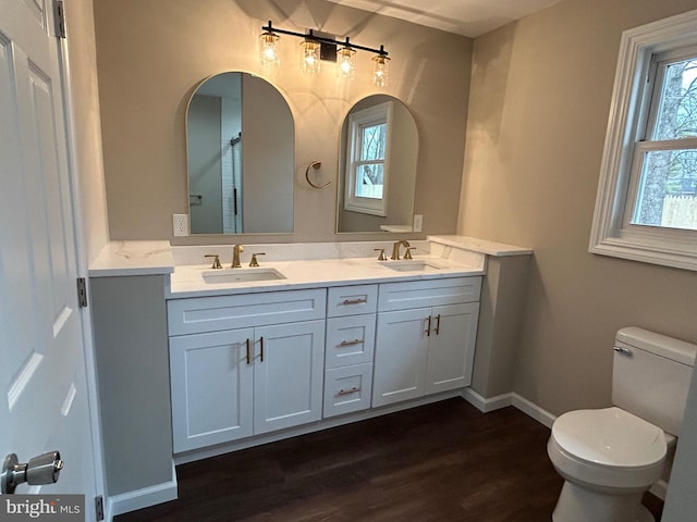 bathroom with vanity, toilet, and hardwood / wood-style floors