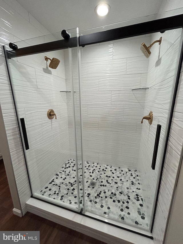 bathroom featuring wood-type flooring and a shower with door