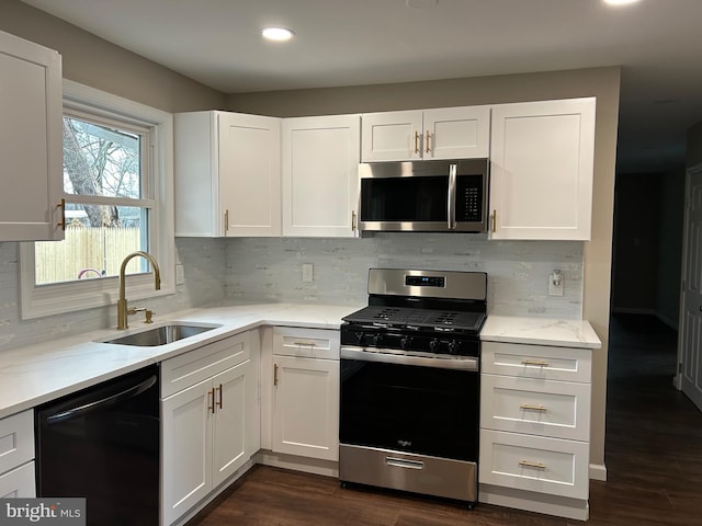 kitchen with sink, white cabinets, tasteful backsplash, and stainless steel appliances