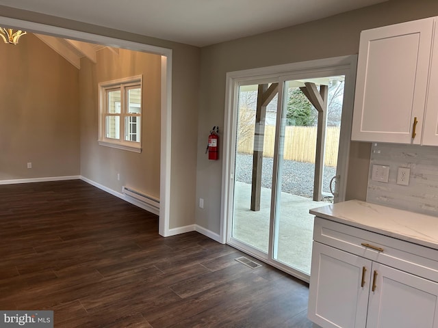 doorway with baseboard heating and dark wood-type flooring