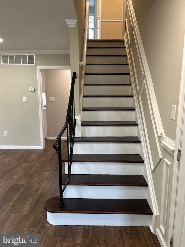 stairs featuring hardwood / wood-style floors and ornamental molding