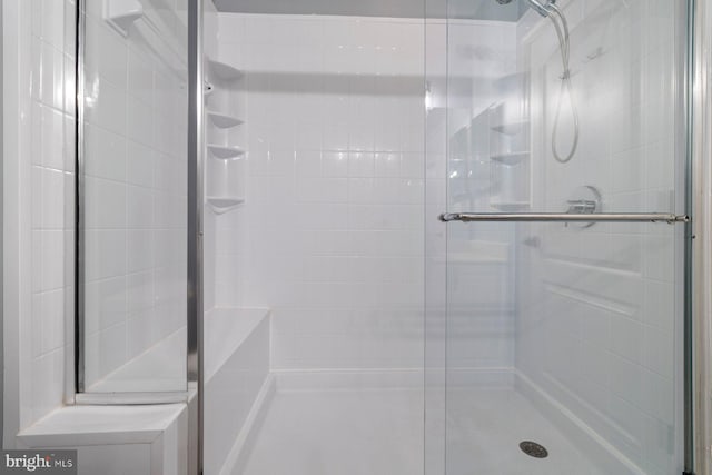 bathroom featuring a shower with shower door