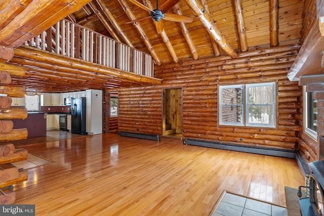 unfurnished living room with rustic walls, wood ceiling, high vaulted ceiling, light wood-type flooring, and beamed ceiling