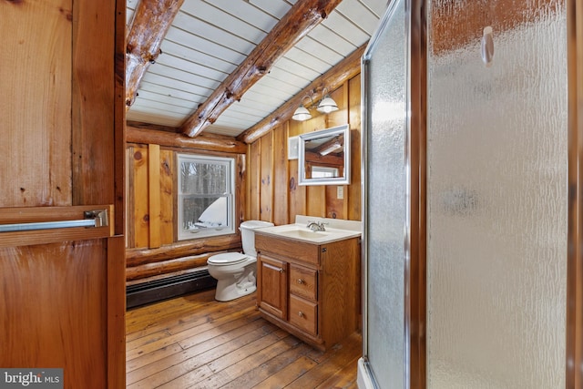 bathroom with a shower with shower door, wood-type flooring, wood walls, vanity, and baseboard heating