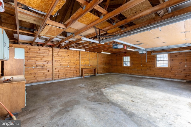 garage with a garage door opener and wooden walls