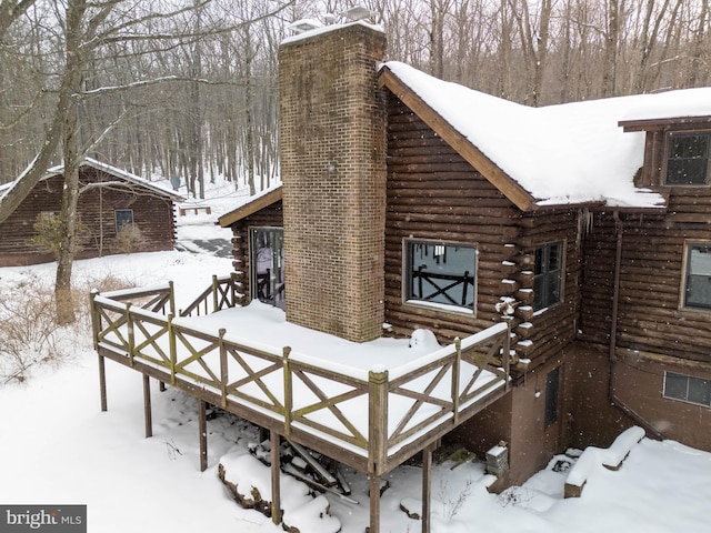 snow covered property with a wooden deck