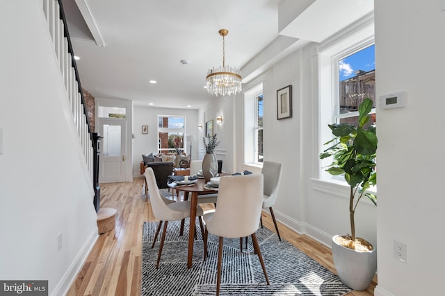 dining room with light hardwood / wood-style floors, an inviting chandelier, and a healthy amount of sunlight