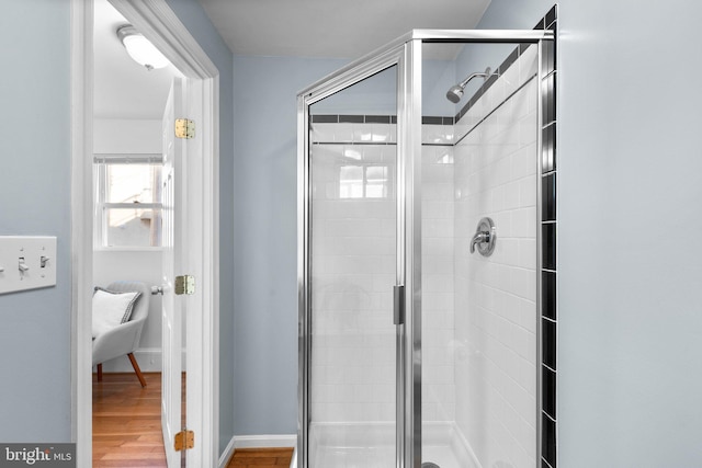 bathroom with an enclosed shower and hardwood / wood-style flooring