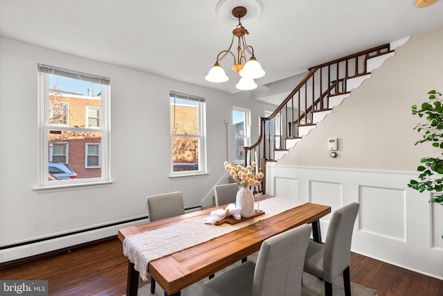 dining room featuring dark wood-type flooring, a notable chandelier, and baseboard heating