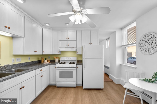 kitchen featuring white cabinetry, light wood-type flooring, ceiling fan, radiator, and white appliances