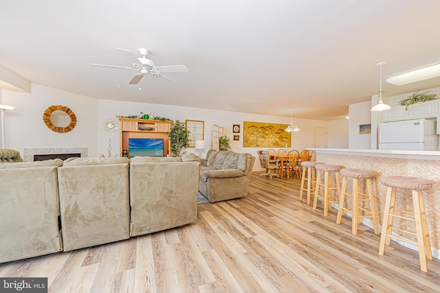 living room with ceiling fan and light hardwood / wood-style flooring