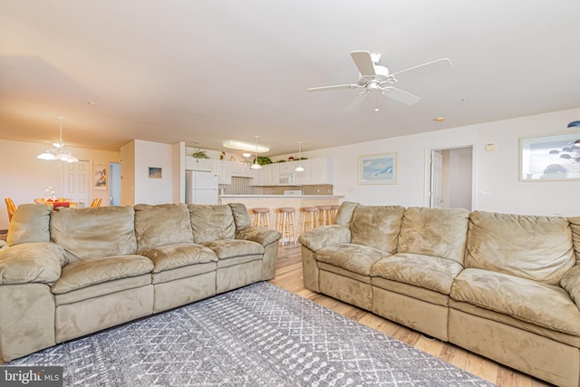 living room with ceiling fan and light wood-type flooring