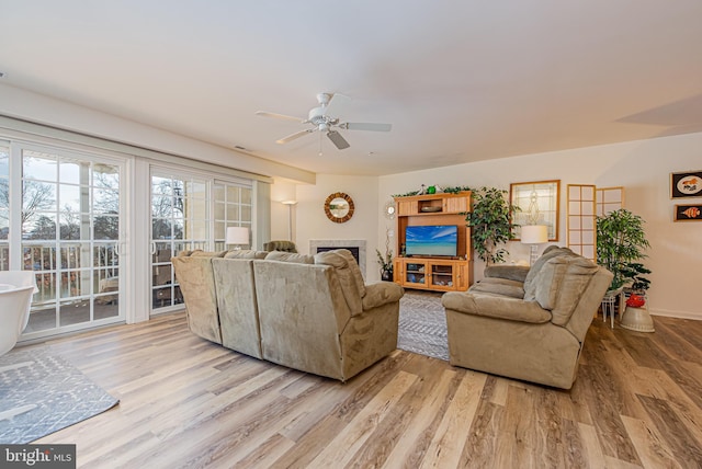 living room featuring ceiling fan and light hardwood / wood-style floors