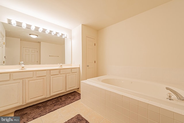 bathroom featuring tile patterned flooring, a relaxing tiled tub, and vanity