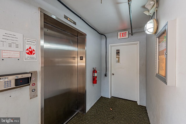 hall featuring dark tile patterned floors