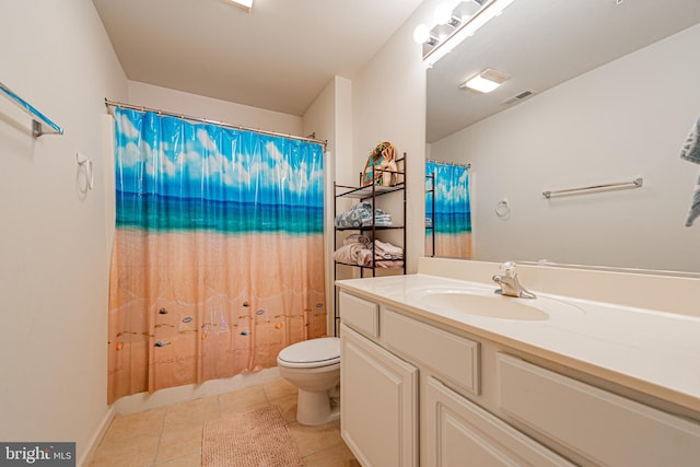 bathroom with toilet, vanity, and tile patterned flooring