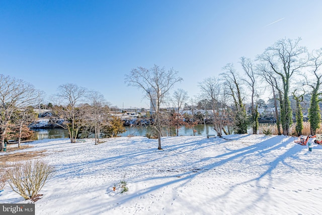 yard covered in snow featuring a water view