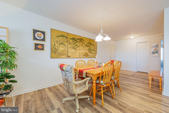 dining room featuring light wood-type flooring and a chandelier