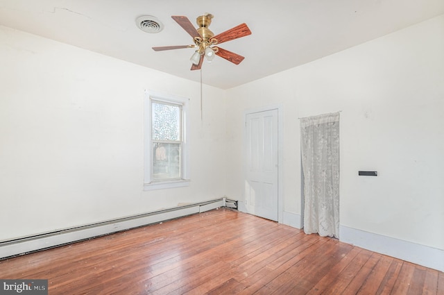 unfurnished room with hardwood / wood-style floors, a ceiling fan, visible vents, and baseboard heating