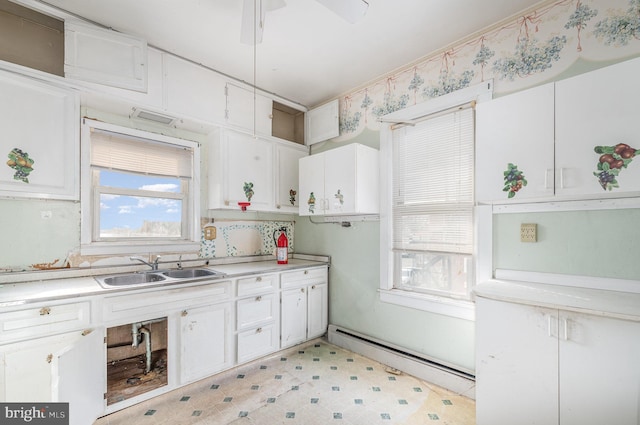 kitchen featuring white cabinetry, light countertops, a baseboard radiator, and a sink