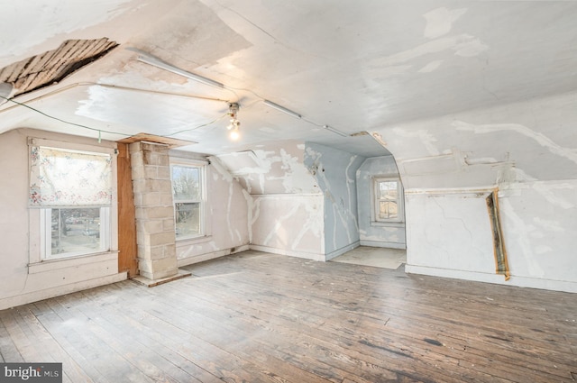 additional living space with vaulted ceiling and wood-type flooring