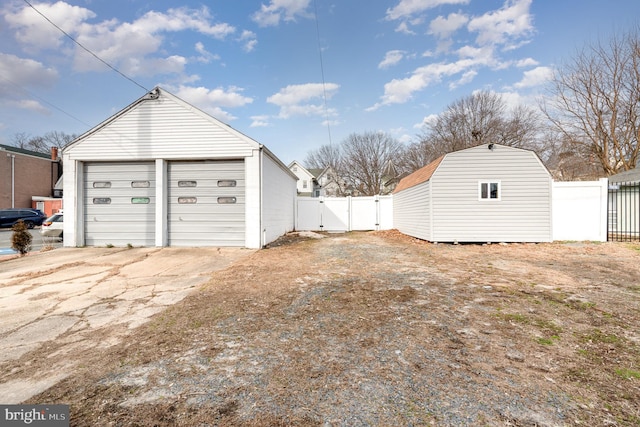 detached garage featuring a gate and fence