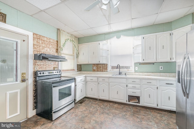 kitchen featuring under cabinet range hood, appliances with stainless steel finishes, white cabinets, a paneled ceiling, and a sink