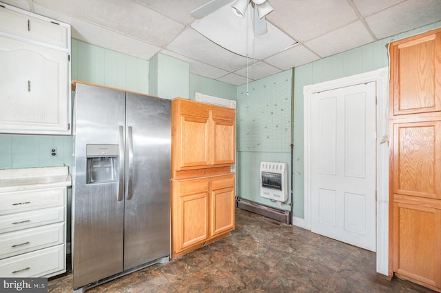 kitchen with heating unit, a ceiling fan, light countertops, a paneled ceiling, and stainless steel refrigerator with ice dispenser