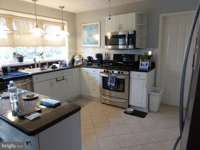 kitchen with backsplash, white cabinets, stainless steel appliances, and light tile patterned floors