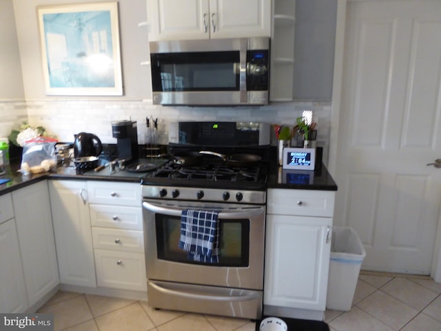 kitchen with decorative backsplash, appliances with stainless steel finishes, white cabinetry, and light tile patterned floors