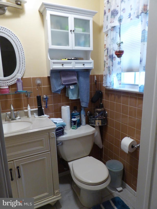 bathroom featuring vanity, toilet, and tile walls