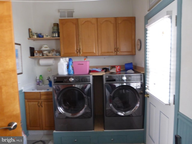 clothes washing area with cabinets, washer and clothes dryer, and sink