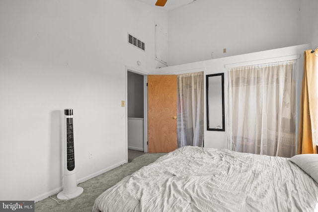 carpeted bedroom featuring ceiling fan and a towering ceiling